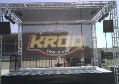 16’W x 32’L x 15’H high truss structure (four towers) with scrim shade roof & black scrim backdrop